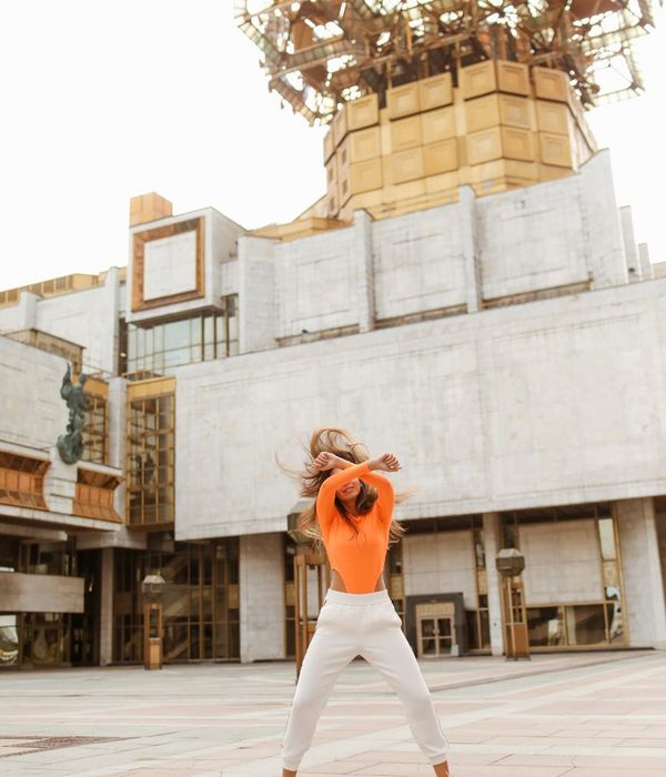Woman performing a light cardio movement in a bright, modern space.
